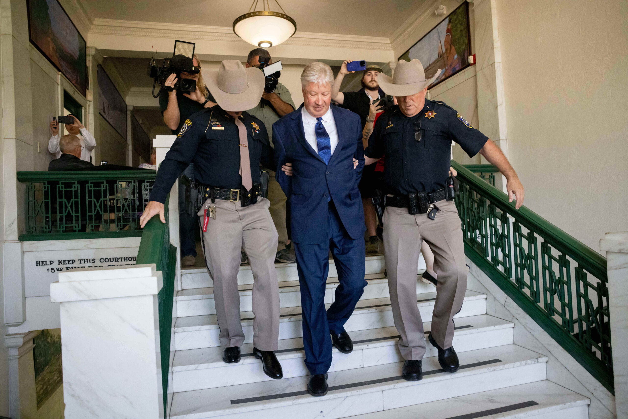 Texas megachurch founder Robert Morris is escorted out of the building after pleading guilty to lewd and indecent acts with a child