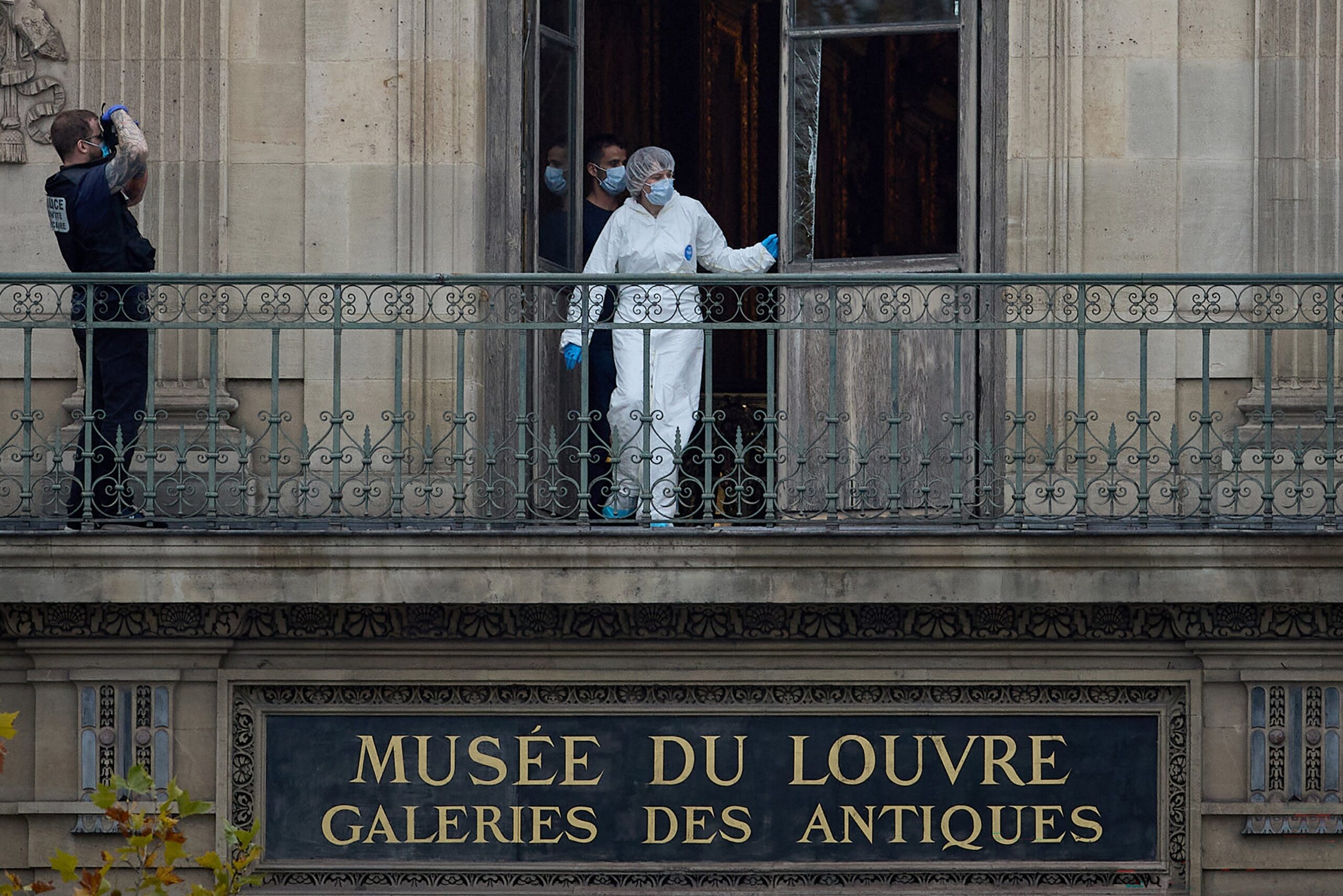 A French Forensics Officer examines the cut window and balcony of a gallery at the Louvre Museum after a robbery at the world famous museum