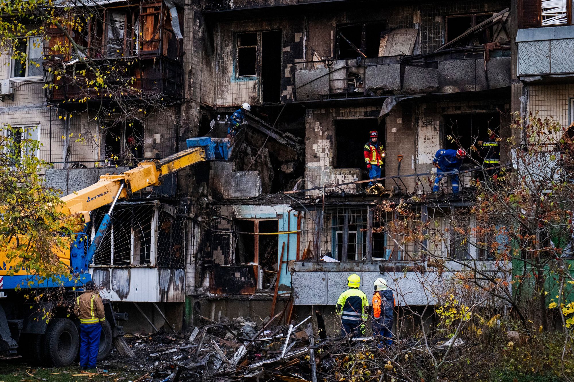 Firefighters work at a destroyed apartment building after a Russian drone attack in Kyiv