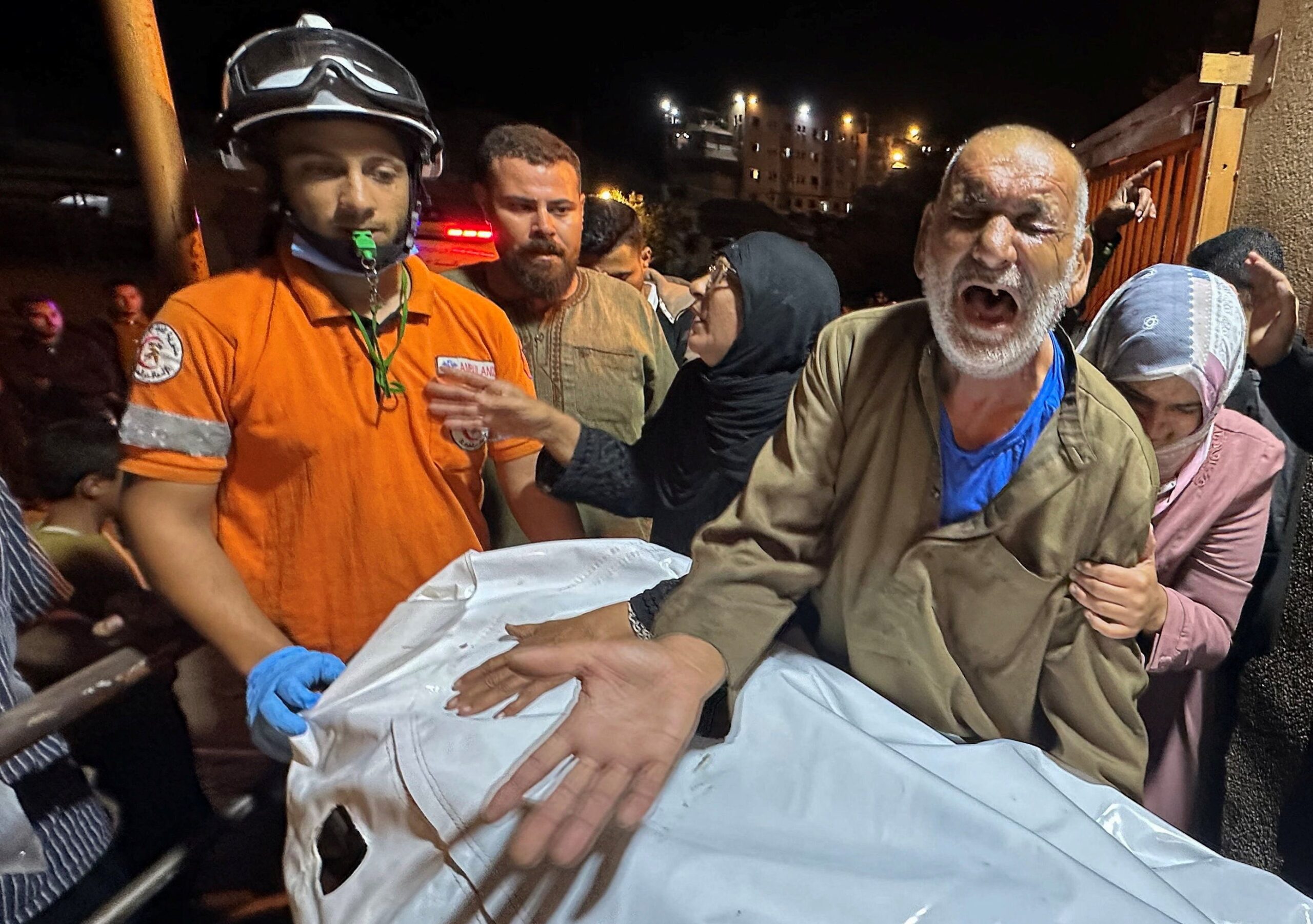 A Palestinian man reacts next to the body of a man, who medics say was killed in a strike on Tuesday