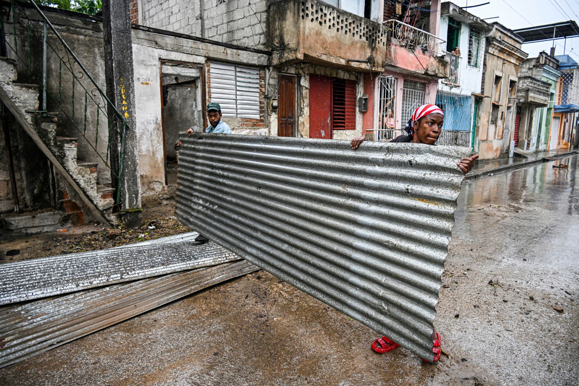 Residents hold pieces of a roof before Hurricane Melissa arrives in Santiago de Cuba, Cuba, on Tuesday. The storm is expected to hit Cuba early Wednesday morning