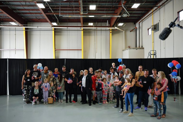 DULLES, VIRGINIA - MAY 12: Newly arrived South Africans wait to hear welcome statements from U.S. government officials in a hangar at Atlantic Aviation Dulles near Washington Dulles International Airport on May 12, 2025 in Dulles, Virginia. Dozens of white South Africans, also called Afrikaners, accepted an invitation from the Trump Administration to come to the United States as refugees. They say they are fleeing job discrimination and racial violence in their home country. Trump has halted virtually all refugee admissions for people fleeing famine and war but has created an expedited path into the U.S. for Afrikaners, descendants of white Europeans who created and led the brutal apartheid regime in South Africa from 1948 to 1994. (Photo by Chip Somodevilla/Getty Images)