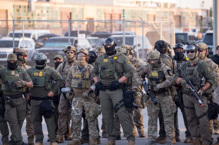 BROADVIEW, ILLINOIS - SEPTEMBER 27: U.S. Immigration and Customs Enforcement (ICE) agents, Department of Homeland Security (DHS) personnel, and Border Patrol Commander Gregory Bovino stand together amidst a tense protest outside the ICE processing facility in Broadview, Illinois, on September 27, 2025. Demonstrators gathered to oppose the Trump administration's immigration enforcement operations, including 'Operation Midway Blitz,' as clashes escalated with reports of tear gas and pepper balls used to disperse crowds. (Photo by Jacek Boczarski/Anadolu via Getty Images)