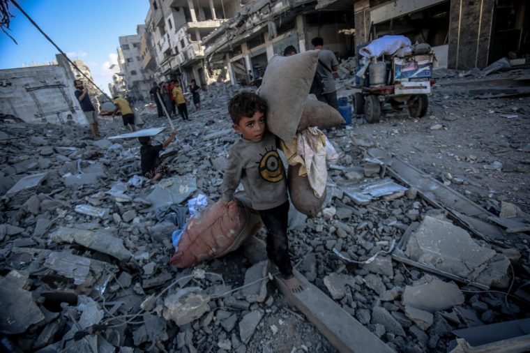 GAZA CITY, GAZA - SEPTEMBER 30: Palestinian children collect usable belongings from the rubble after the Israeli strike on Abu Hasira Street in Gaza City, Gaza, on September 30, 2025. Several buildings were completely destroyed, and many others were severely damaged in the strike. (Photo by Saeed M. M. T. Jaras/Anadolu via Getty Images)
