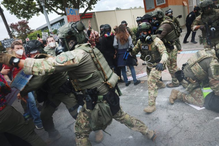 PORTLAND, OREGON - OCTOBER 04: Federal agents, including members of the Department of Homeland Security, the Border Patrol, and police, clash with protesters outside a downtown U.S. Immigration and Customs Enforcement (ICE) facility on October 04, 2025 in Portland, Oregon. The facility has become a focal point of nightly protests against the Trump administration and his announcement that he will be sending National Guard troops into Portland. A federal judge is currently hearing Oregon???s case against sending troops into the city, and a decision is expected on Saturday. (Photo by Spencer Platt/Getty Images)