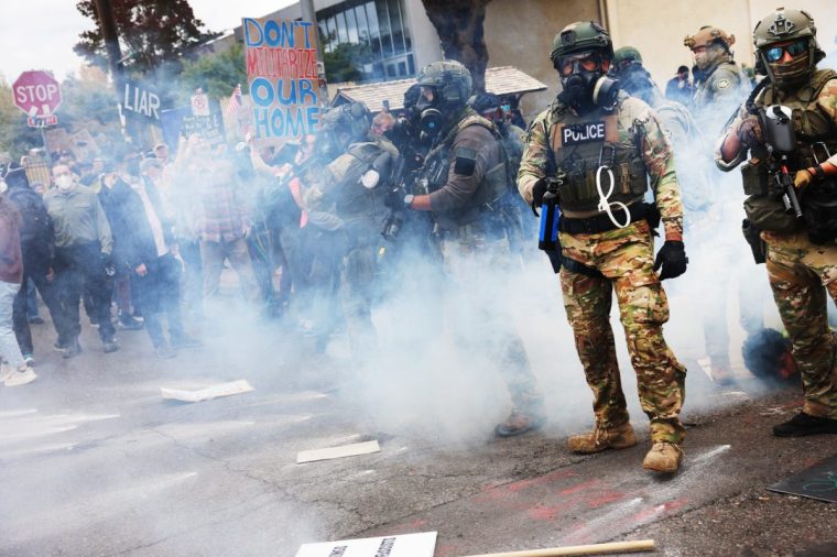 PORTLAND, OREGON - OCTOBER 04: Federal agents, including members of the Department of Homeland Security, the Border Patrol, and police, clash with protesters outside a downtown U.S. Immigration and Customs Enforcement (ICE) facility on October 04, 2025 in Portland, Oregon. The facility has become a focal point of nightly protests against the Trump administration and his announcement that he will be sending National Guard troops into Portland. A federal judge is currently hearing Oregon???s case against sending troops into the city, and a decision is expected on Saturday. (Photo by Spencer Platt/Getty Images)