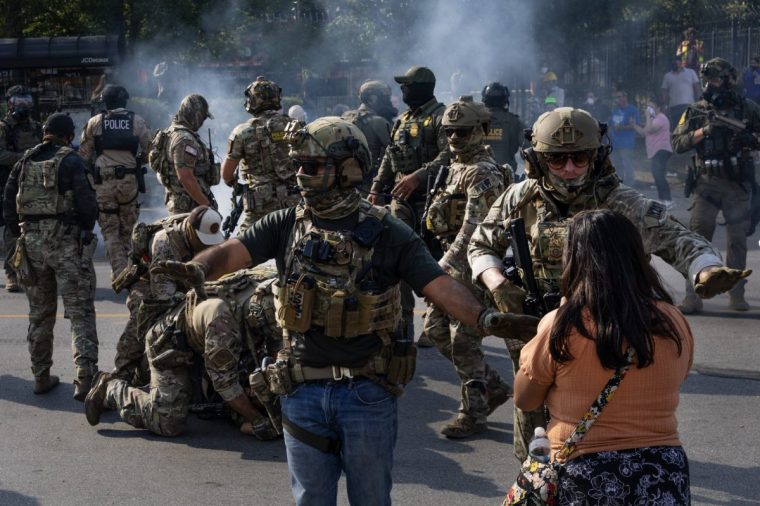 CHICAGO, ILLINOIS - OCTOBER 04: Police take two people into custody, as tear gas fills the air after it was used by federal law enforcement agents who were being confronted by community members and activists for reportedly shooting a woman in the Brighton Park neighborhood on October 04, 2025 in Broadview, Illinois. Residents of the city have become increasingly concerned as Operation Midway Blitz continues in the Chicago area, an operation designed to apprehend and deport undocumented immigrants living in the area. (Photo by Scott Olson/Getty Images)