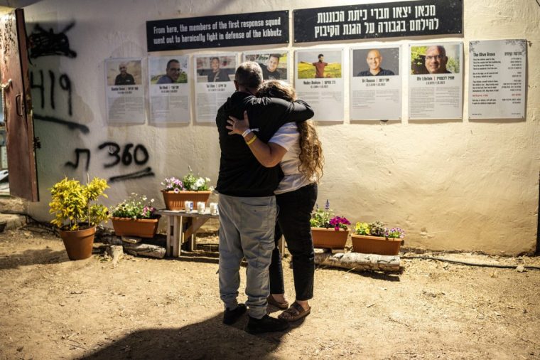 Two people embrace ahead of a memorial ceremony for the victims of the 2023 October 7 attacks at the Nova Festival grounds in Reim in southern Israel on the second anniversary of the attacks on October 7, 2025. Israel marks the second anniversary of the October 7, 2023 attack as Hamas and Israeli negotiators hold indirect talks to end the two-year war in Gaza under a US-proposed peace plan. Two years prior to the day, at the close of the Jewish festival of Sukkot, Hamas-led militants launched a massive assault on Israel, making it the deadliest day in the country's history. (Photo by JOHN WESSELS / AFP) (Photo by JOHN WESSELS/AFP via Getty Images)