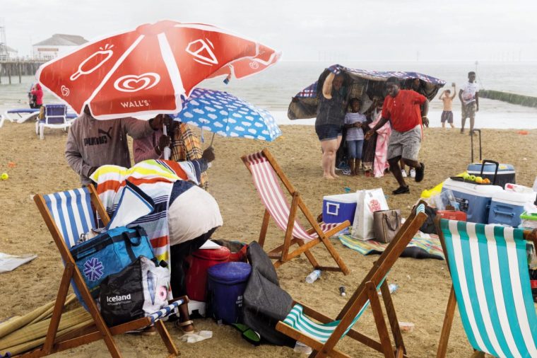 A 2017 photo from Martin Parr's series The Great British Seaside shows beachgoers scrabbling for shelter in the rain ( Photo: Martin Parr/Magnum)