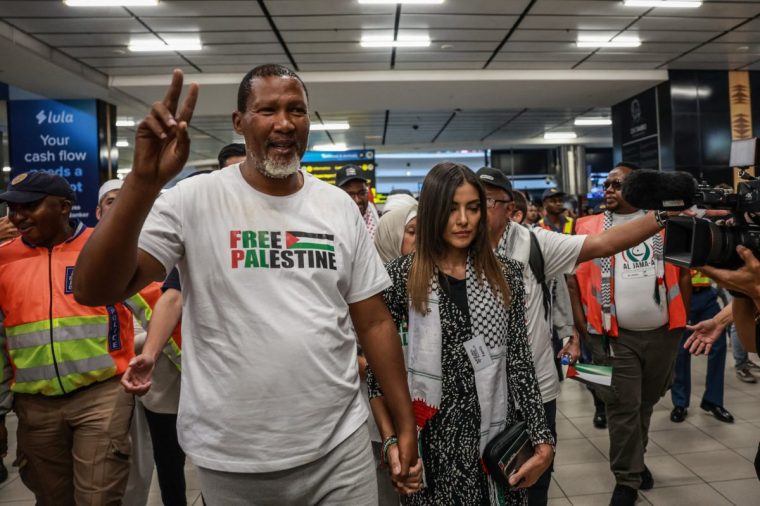 Mandla Mandela (L), South African activist and grandson of the late Nelson Mandela shows a peace sign accompanied by his wife Rabia Mandela (R) as he arrives with others at OR Tambo International Airport in Kempton Park on October 8, 2025 after being stopped, detained and later released by Israeli forces while sailing aboard vessels from the Gaza-bound aid flotilla. (Photo by Phill Magakoe / AFP) (Photo by PHILL MAGAKOE/AFP via Getty Images)