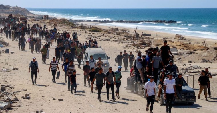 Palestinians, who were displaced to the southern part of Gaza at Israel's order during the war, make their way following their arrival in Gaza City after a ceasefire between Israel and Hamas in Gaza went into effect, October 10, 2025. REUTERS/Ebrahim Hajjaj