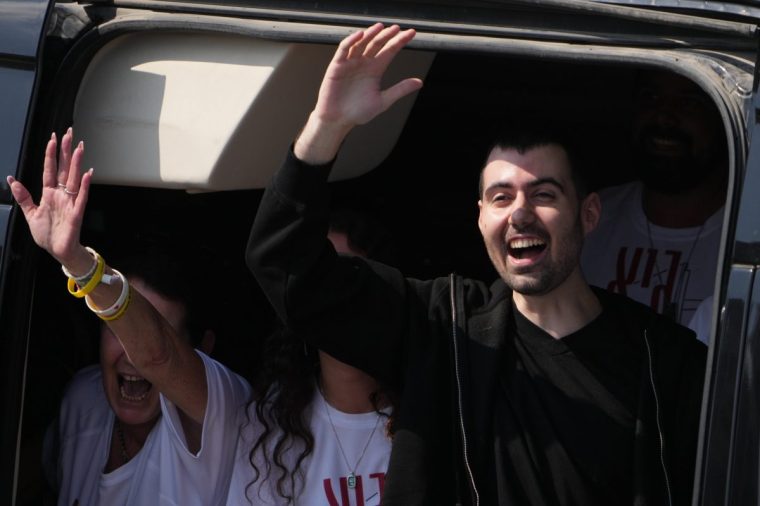 Freed Israeli hostage Guy Gilboa-Dalal gestures from a van as he arrives at Beilinson hospital in Petah Tikva, Israel, after he was released from Hamas captivity in the Gaza Stripl, Monday, Oct. 13, 2025. (AP Photo/Ariel Schalit)