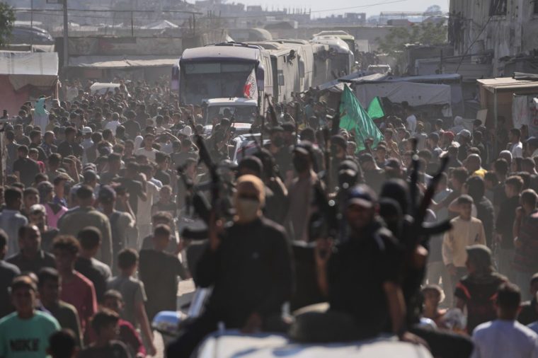 Hamas gunmen in escort buses carrying freed Palestinian prisoners arriving in the Gaza Strip after their release from Israeli jails under a ceasefire agreement between Hamas and Israel, in Khan Younis, southern Gaza Strip, Monday, Oct. 13, 2025. (AP Photo/Jehad Alshrafi)