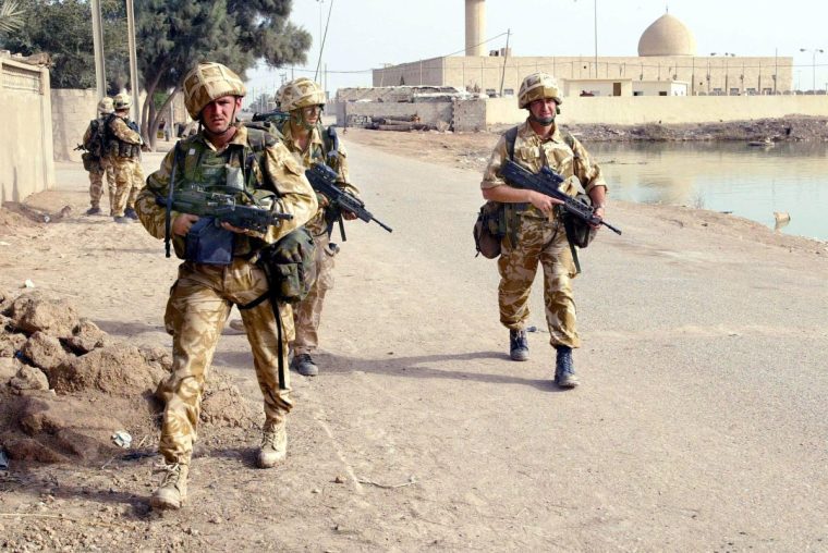 TOPSHOT - A picture issued 23 March 2003 shows soldiers from Britain's 40 Commando Royal Marines moving towards the centre of the town of Fao in southern Iraq 22 March. AFP PHOTO POOL TERRY RICHARDS (Photo by TERRY RICHARDS / POOL / AFP) (Photo by TERRY RICHARDS/POOL/AFP via Getty Images)