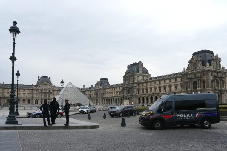 French police officers stand in front of the Louvre Museum after robbery, in Paris on October 19, 2025. Robbers broke in to the Louvre and fled with jewellery on October 19, 2025 morning, a source close to the case said, adding that its value was still being evaluated. A police source said an unknown number of thieves arrived on a scooter armed with small chainsaws and used a goods lift to reach the room they were targeting. (Photo by Dimitar DILKOFF / AFP) / -- IMAGE RESTRICTED TO EDITORIAL USE - STRICTLY NO COMMERCIAL USE -- (Photo by DIMITAR DILKOFF/AFP via Getty Images)