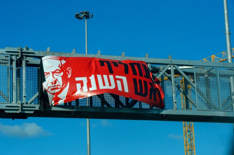 TEL AVIV, ISRAEL - OCTOBER 28: A large banner bearing the image of Israeli Prime Minister Benyamin Netanyahu and calling for his removal as head of the government is seen above a motorway on October 28, 2025 on the outskirts of Tel Aviv, Israel. Protests and demonstrations criticizing Netanyahu's government have been ongoing since 2023 prior to the Hamas attack of October 7, 2025 and the subsequent war and current fragile ceasefire with Hamas. (Photo by Martin Grimes/Getty Images)