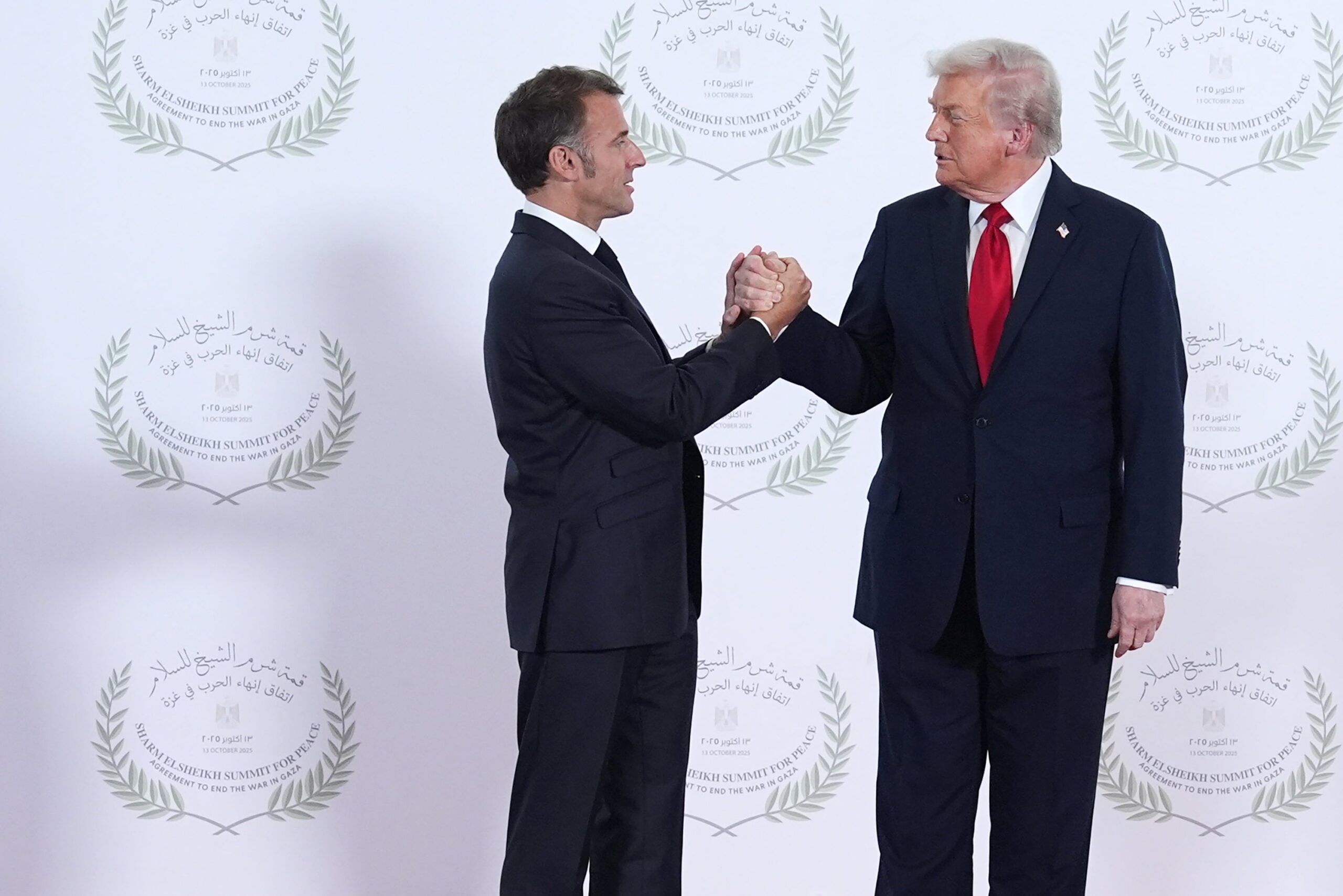 President Donald Trump greets French President Emmanuel Macron during a world leaders' summit on ending the Gaza war on 13 October 2025 in Sharm El-Sheikh, Egypt