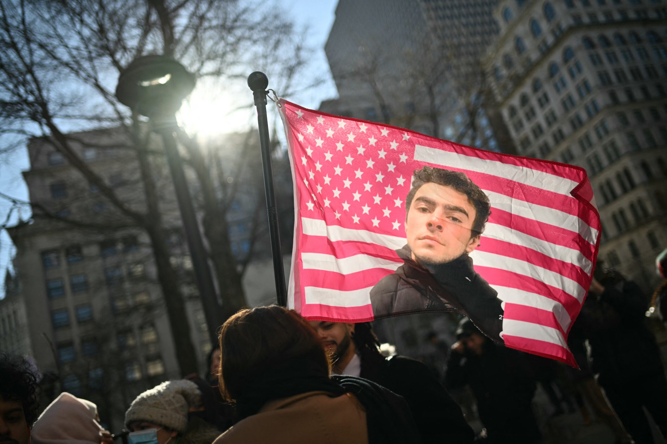 Protesters hold signs outside the Criminal Court where Luigi Mangione, accused killer of US insurance CEO Brian Thompson, attends a hearing in New York City