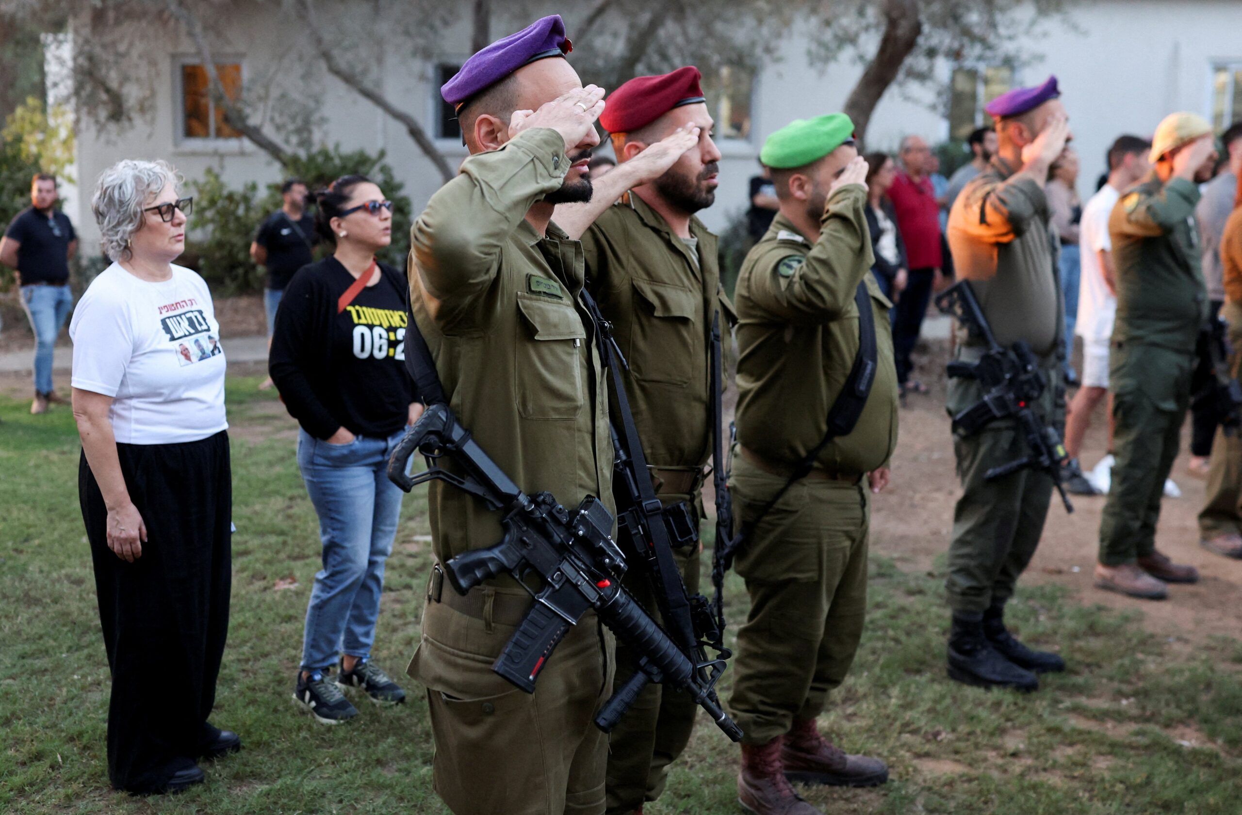 Members of Israeli Defense Forces salute during a memorial to commemorate the two-year anniversary of the deadly 7 October 2023 attack on Israel by Hamas