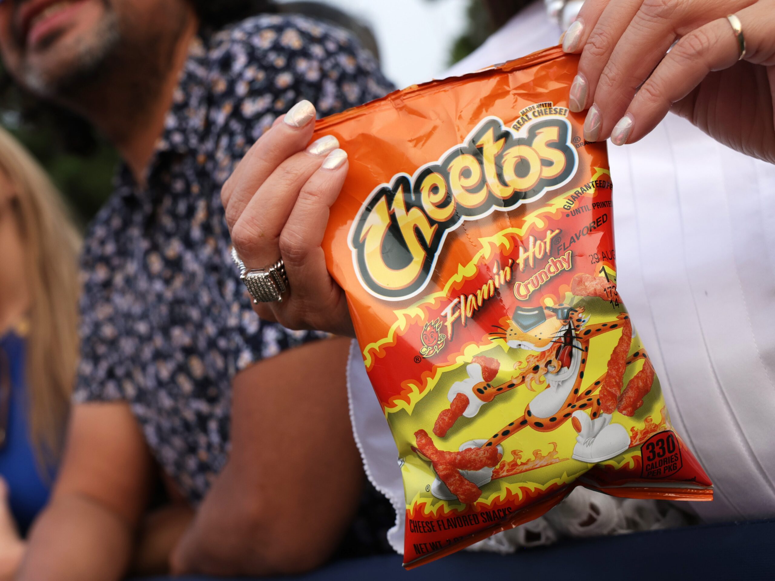 A woman holds bag of Flamin' Hot Cheetos
