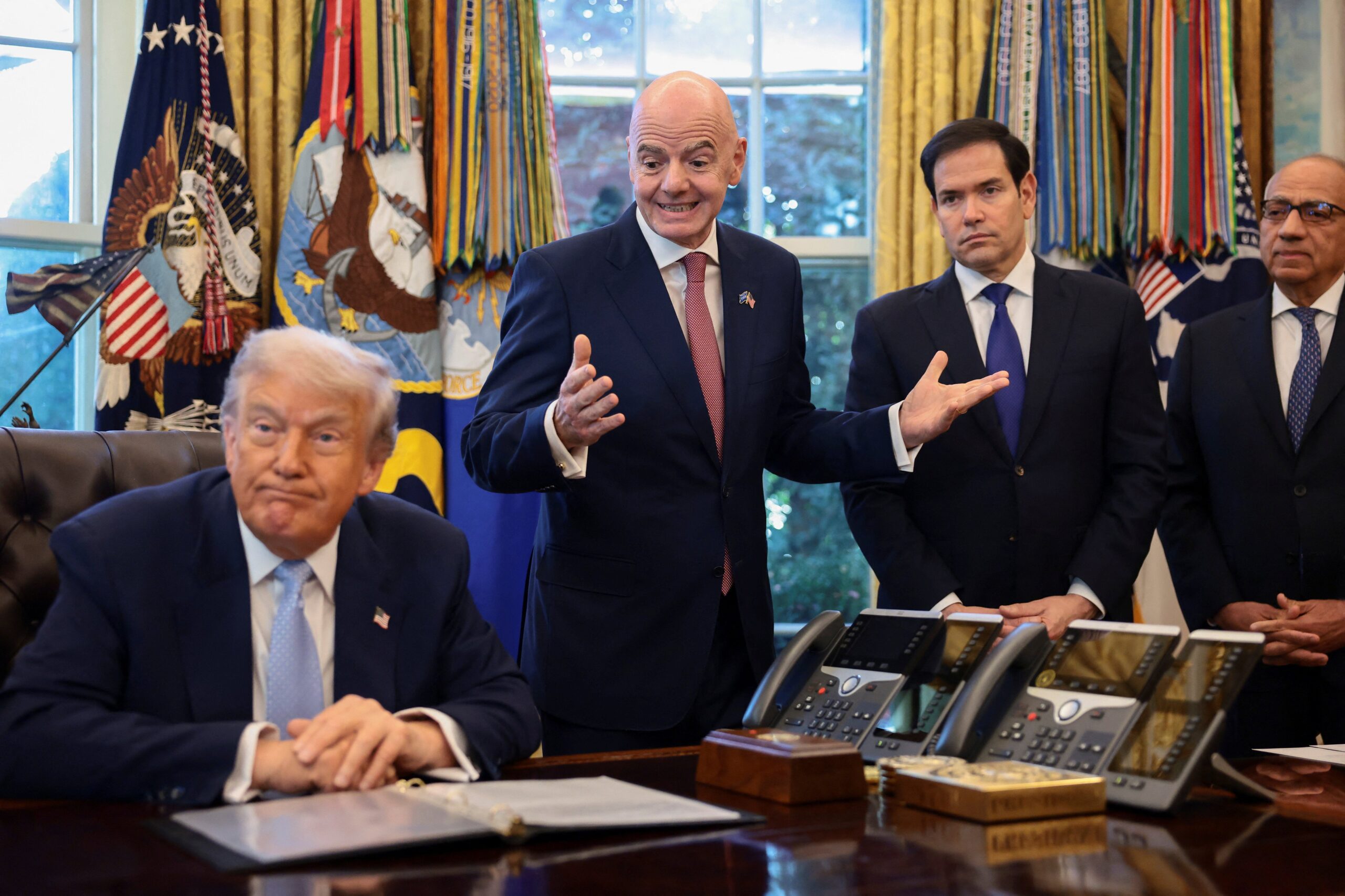 U.S. President Donald Trump sits next to FIFA President Gianni Infantino, U.S. Secretary of State Marco Rubio, and Senior advisor to FIFA president Carlos Cordeiro, as he meets with the White House Task Force on the FIFA World Cup 2026 in the Oval Office at the White House in Washington, D.C., U.S., November 17, 2025. REUTERS/Evelyn Hockstein