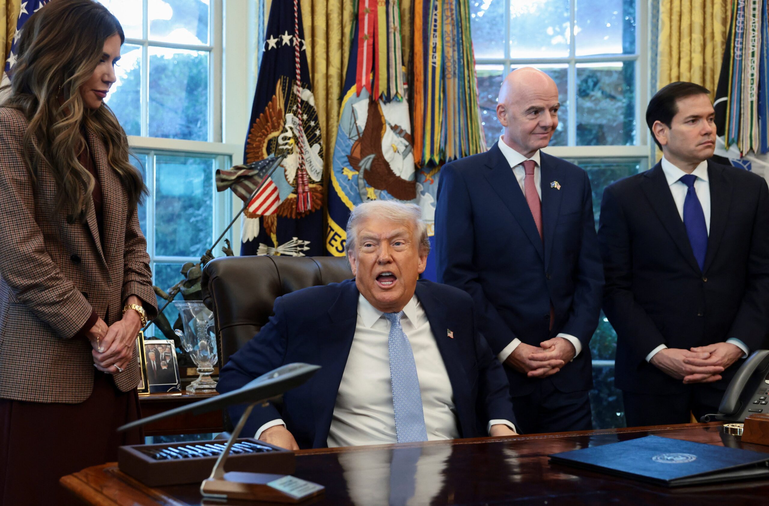 U.S. President Donald Trump speaks while U.S. Homeland Security Secretary Kristi Noem, FIFA President Gianni Infantino and U.S. Secretary of State Marco Rubio stand by his side, as he meets with the White House Task Force on the FIFA World Cup 2026 in the Oval Office at the White House in Washington, D.C., U.S., November 17, 2025. REUTERS/Evelyn Hockstein