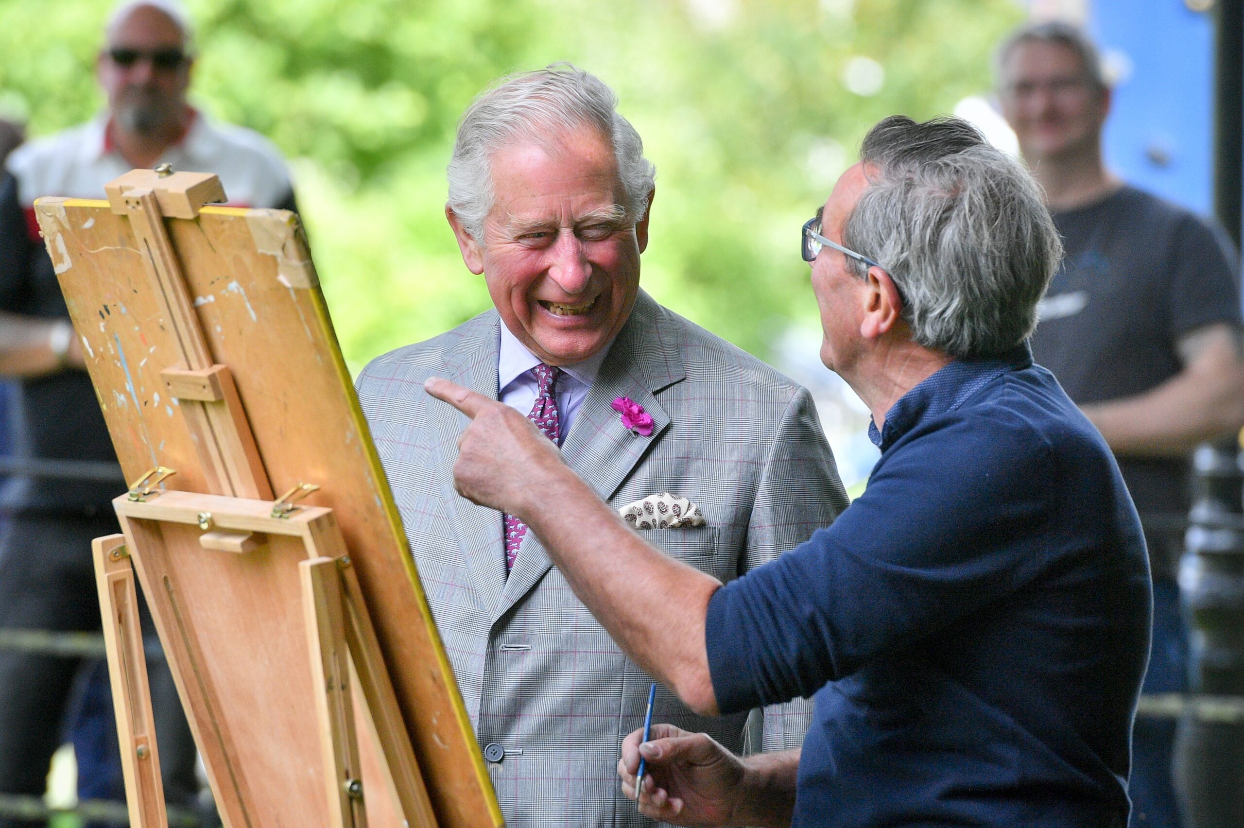 The King chats to an artist working at their easel on a visit to Dorset
