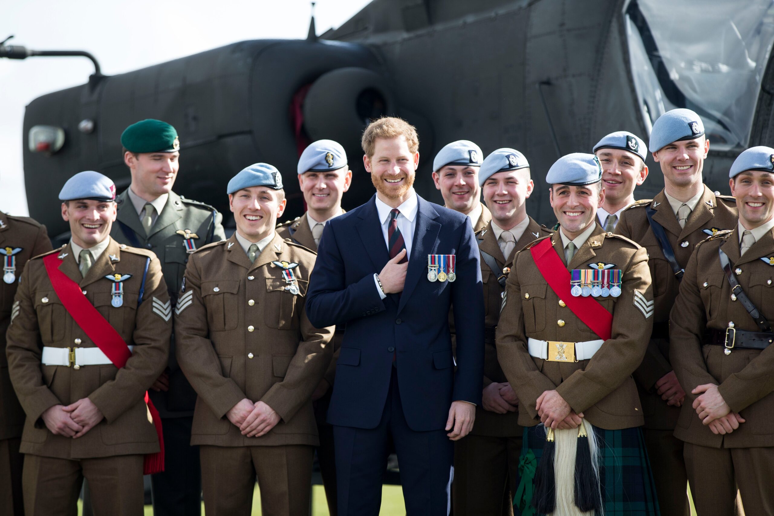 Harry in front of an Apache Helicopter at the Army Aviation Centre after presenting graduates with their Wings in 2018