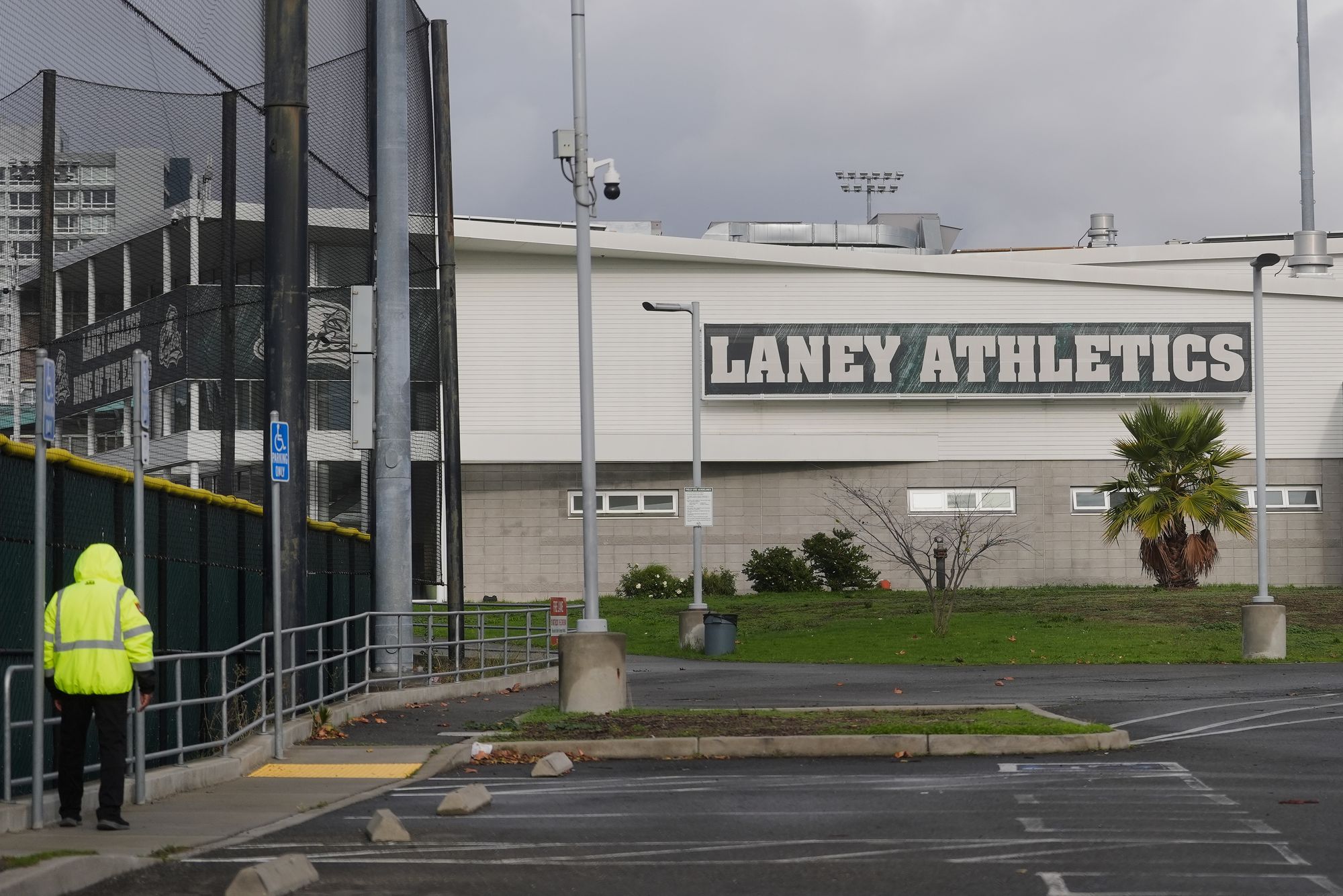 A guard patrols outside of athletics facilities at Laney College, where John Beam was shot and killed