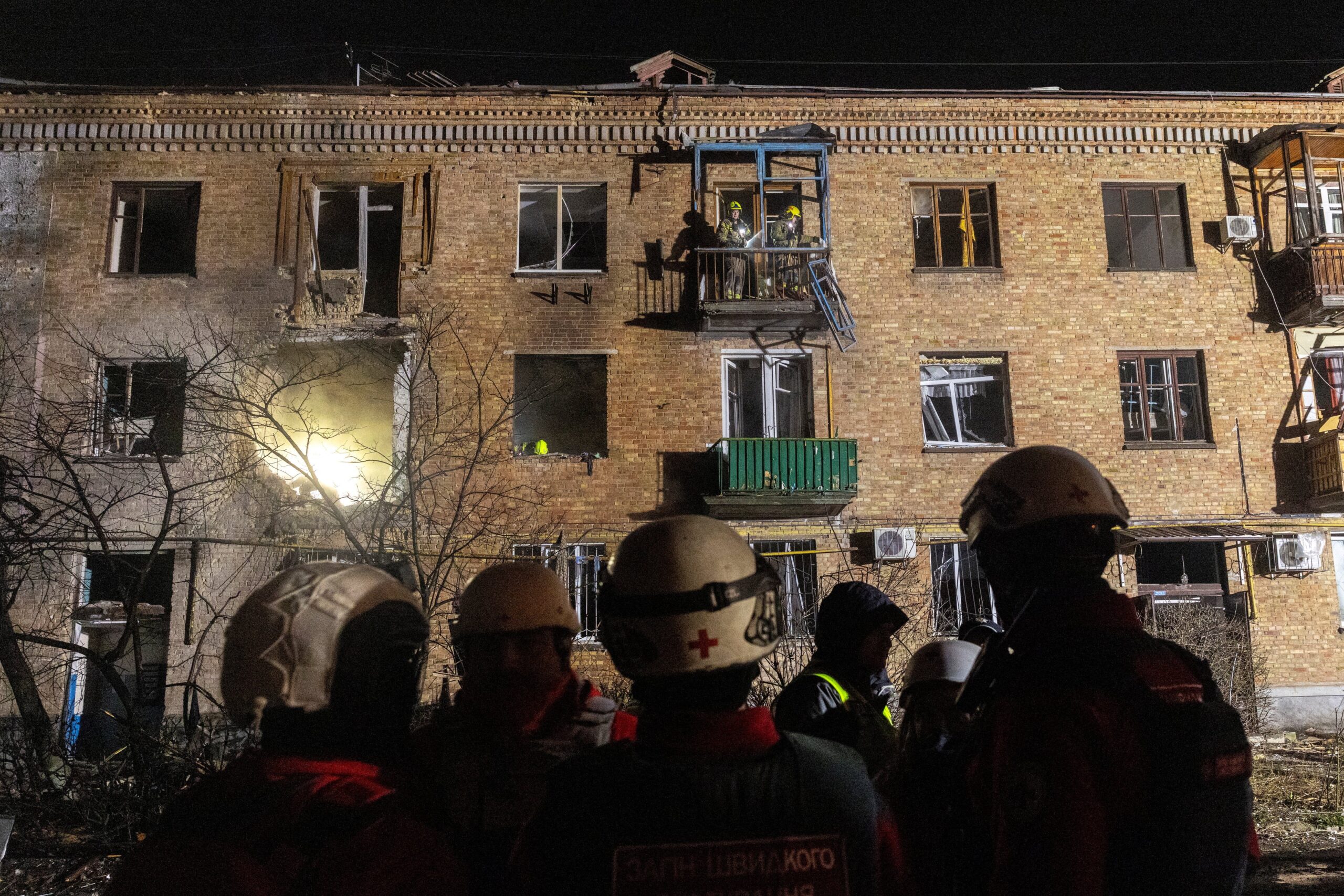 Emergency responders work at the site of an apartment building that was hit during a Russian missile and drone attack on Kyiv