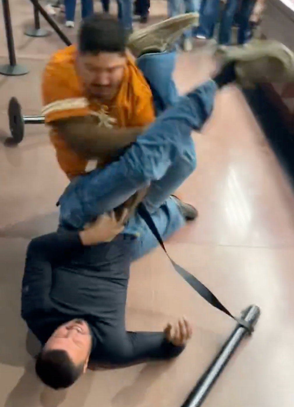 The man wearing a Texas Longhorns jersey tackled the other man before they were eventually separated