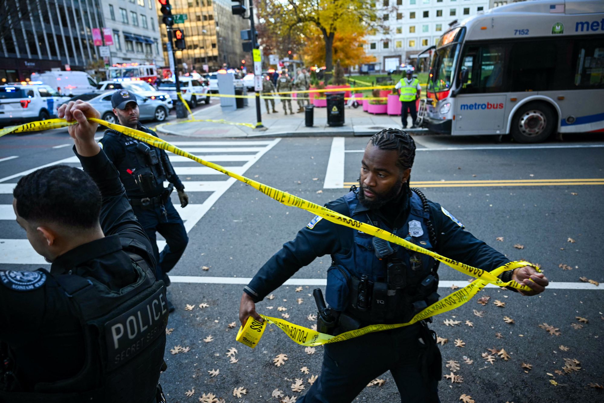 Officers handle police tape at the scene of the shooting in downtown Washington, D.C., on Wednesday