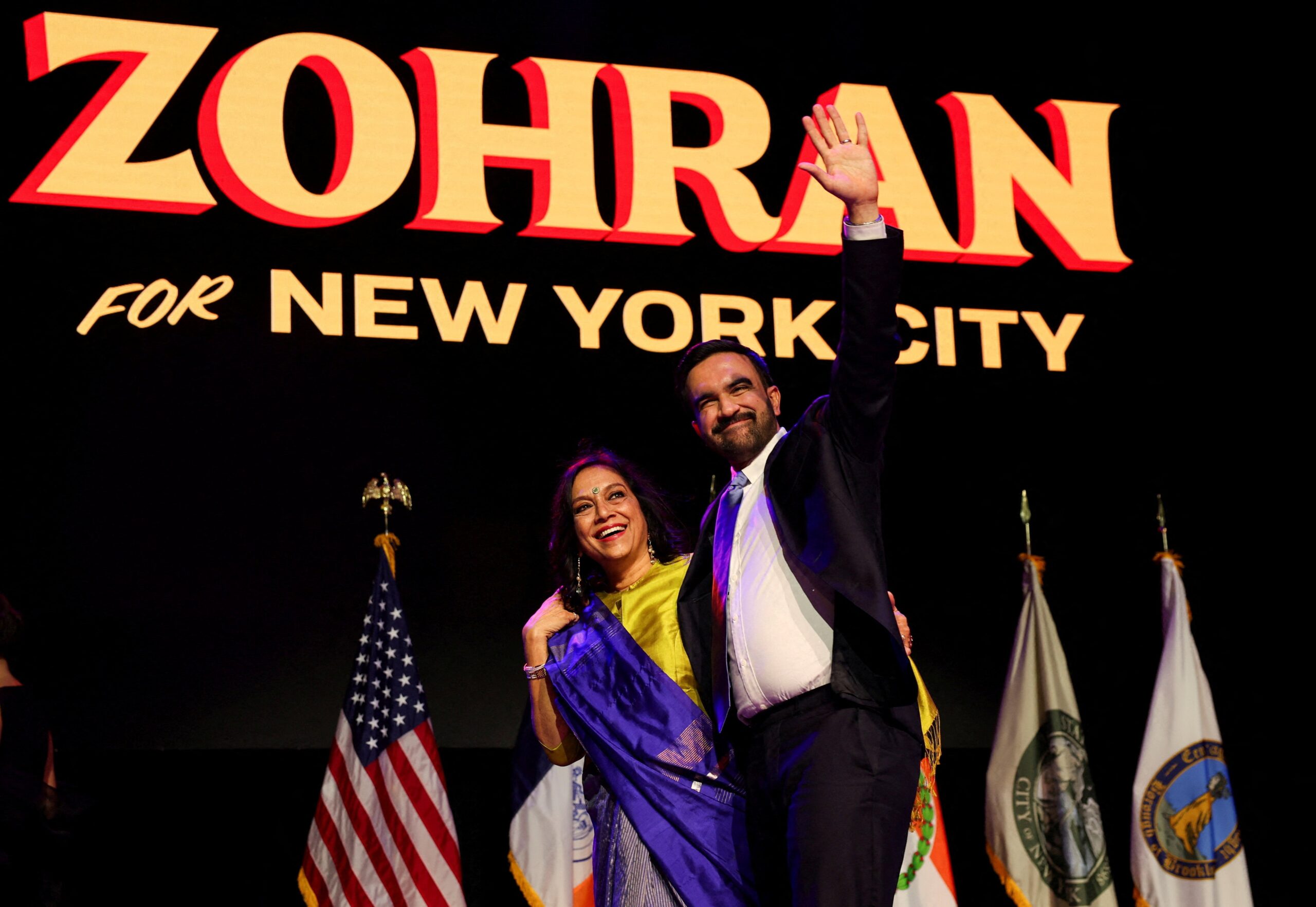 Democratic candidate for New York City mayor Zohran Mamdani waves next to his mother Mira Nair onstage