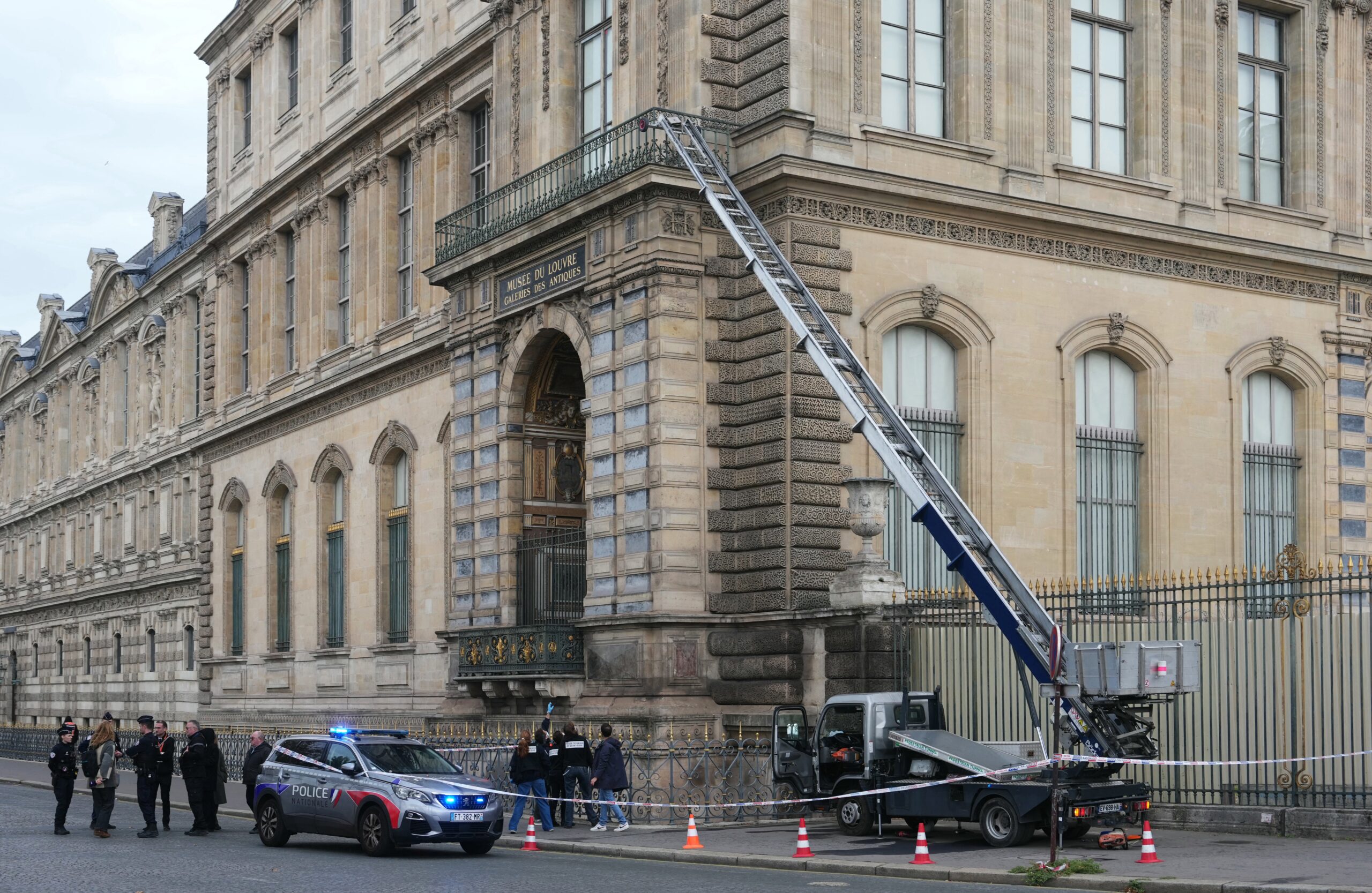 French police officers stand next to a furniture elevator used by robbers to enter the Louvre Museum, on Quai Francois Mitterrand, in Paris on October 19, 2025