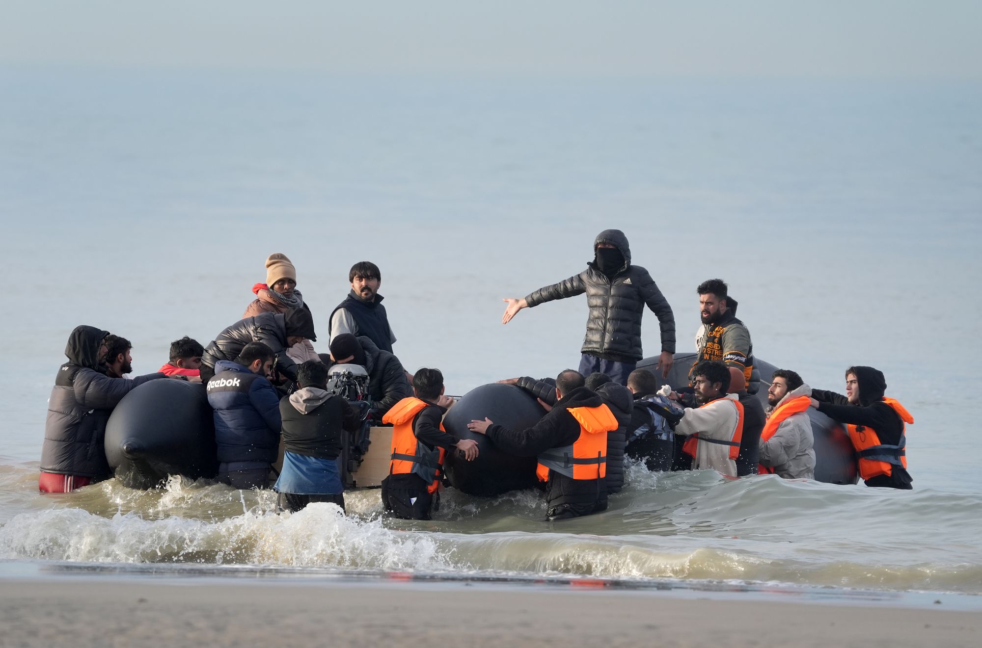 People thought to be migrants attempt to board a small boat in Gravelines, France - where many wait the opportunity to travel across the English Channel to the UK