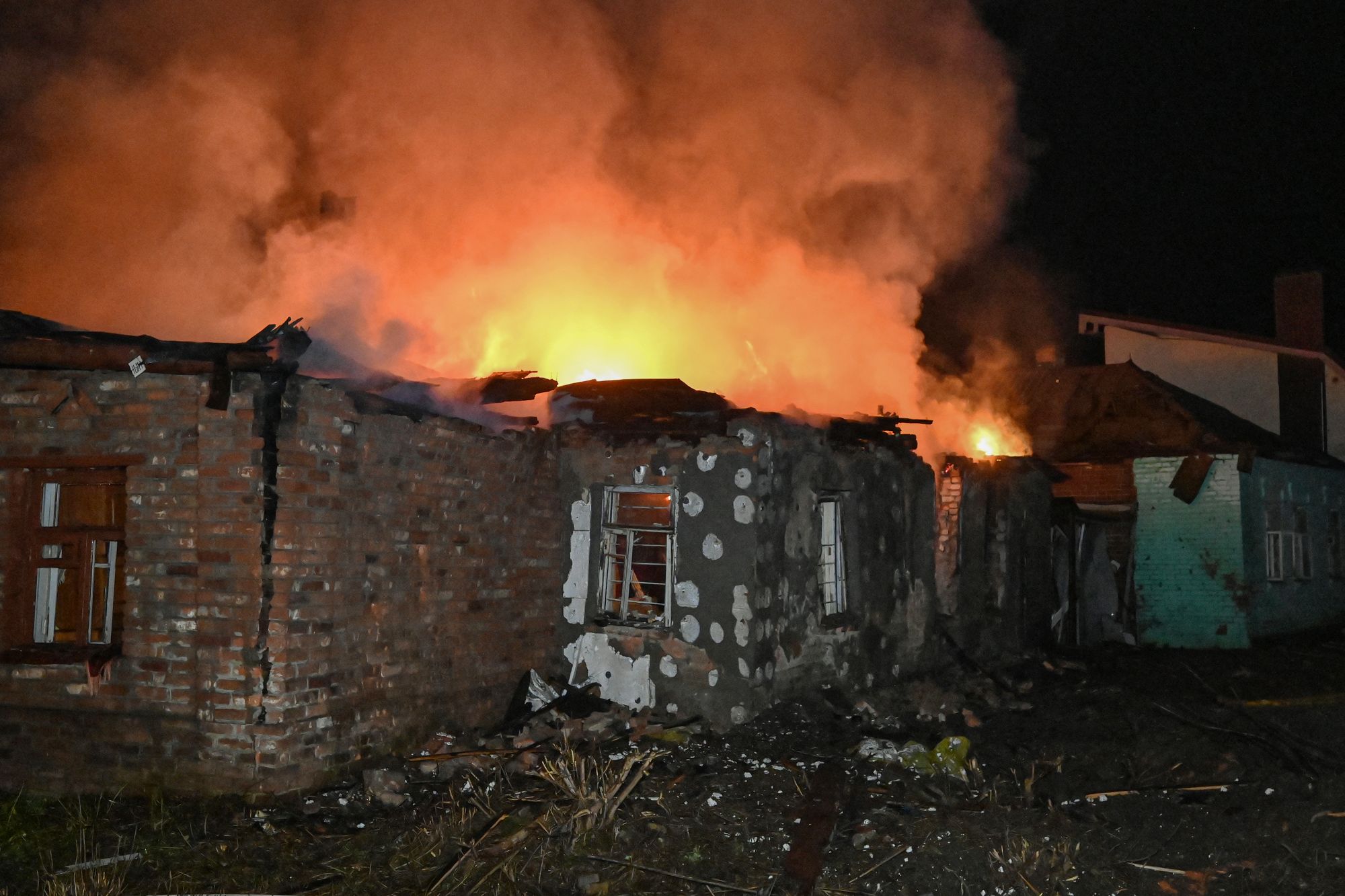 Fire burns at a house that was destroyed in a Russian drone strike in Kharkiv