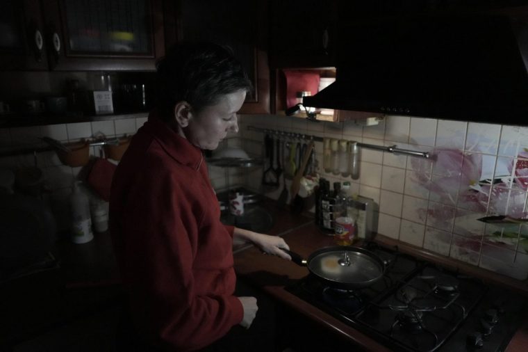 Local resident Olena fries eggs on a gas stove in her apartment during a power outage in Chernigiv on October 22, 2025, following a recent drone attack on critical infrastructure in Chernigiv region, amid the Russian invasion of Ukraine. Russian strikes caused widespread blackouts and cut off phone networks in the northern Ukrainian city of Chernigiv, with repairs stalled by ongoing drone attacks on October 21, 2025. Ukraine has restricted electricity consumption across the country in recent weeks following systematic Russian strikes on energy sites and the rail network. (Photo by Andrew Kravchenko / AFP) (Photo by ANDREW KRAVCHENKO/AFP via Getty Images)
