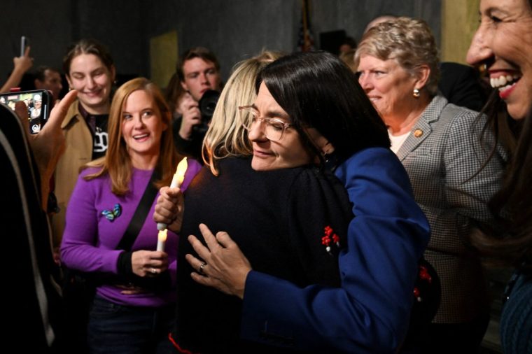 People embrace at the Rayburn House following the U.S. House of Representatives passing the bill to force the release of files related to the late convicted sex offender Jeffrey Epstein, on Capitol Hill in Washington, D.C., U.S., November 18, 2025. REUTERS/Annabelle Gordon