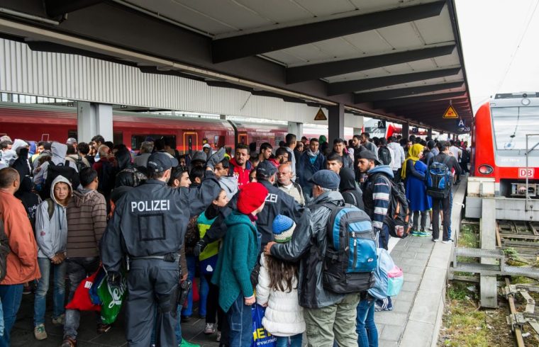 MUNICH, GERMANY - SEPTEMBER 6: Refugees who travelled by train to the main railway station 'Munich Hauptbahnhof' leave the train under control by police and enter another one to get to a refugee centre on September 06, 2015 in Munich, Germany. Hundreds of refugees, mainly from Syria and Iraq, arrive in Germany after Hungary has opened his borders for them to travell on to Germany and Austria. (Photo by Joerg Koch/Anadolu Agency/Getty Images)