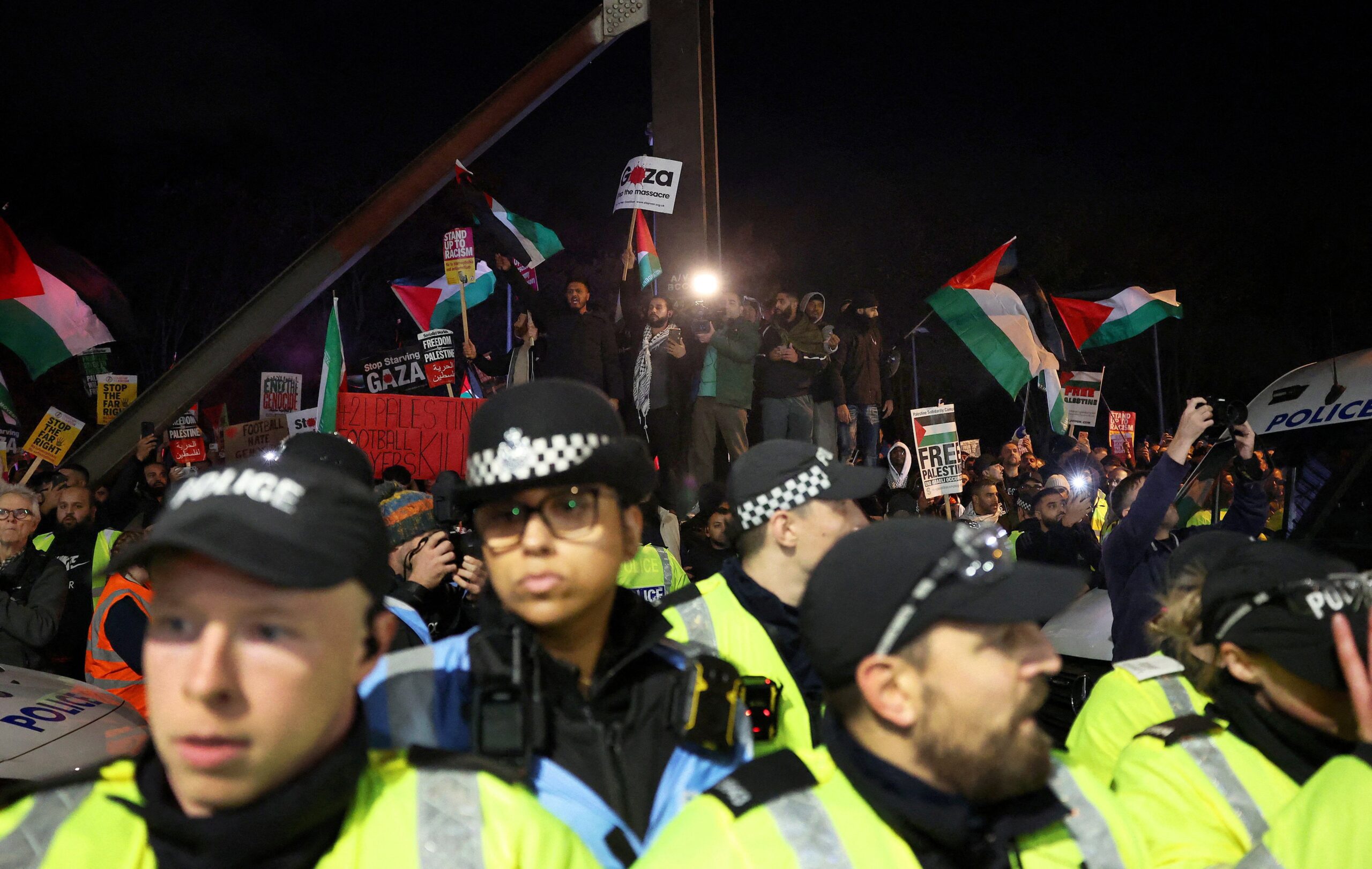 Police officers and protesters outside the stadium before the match