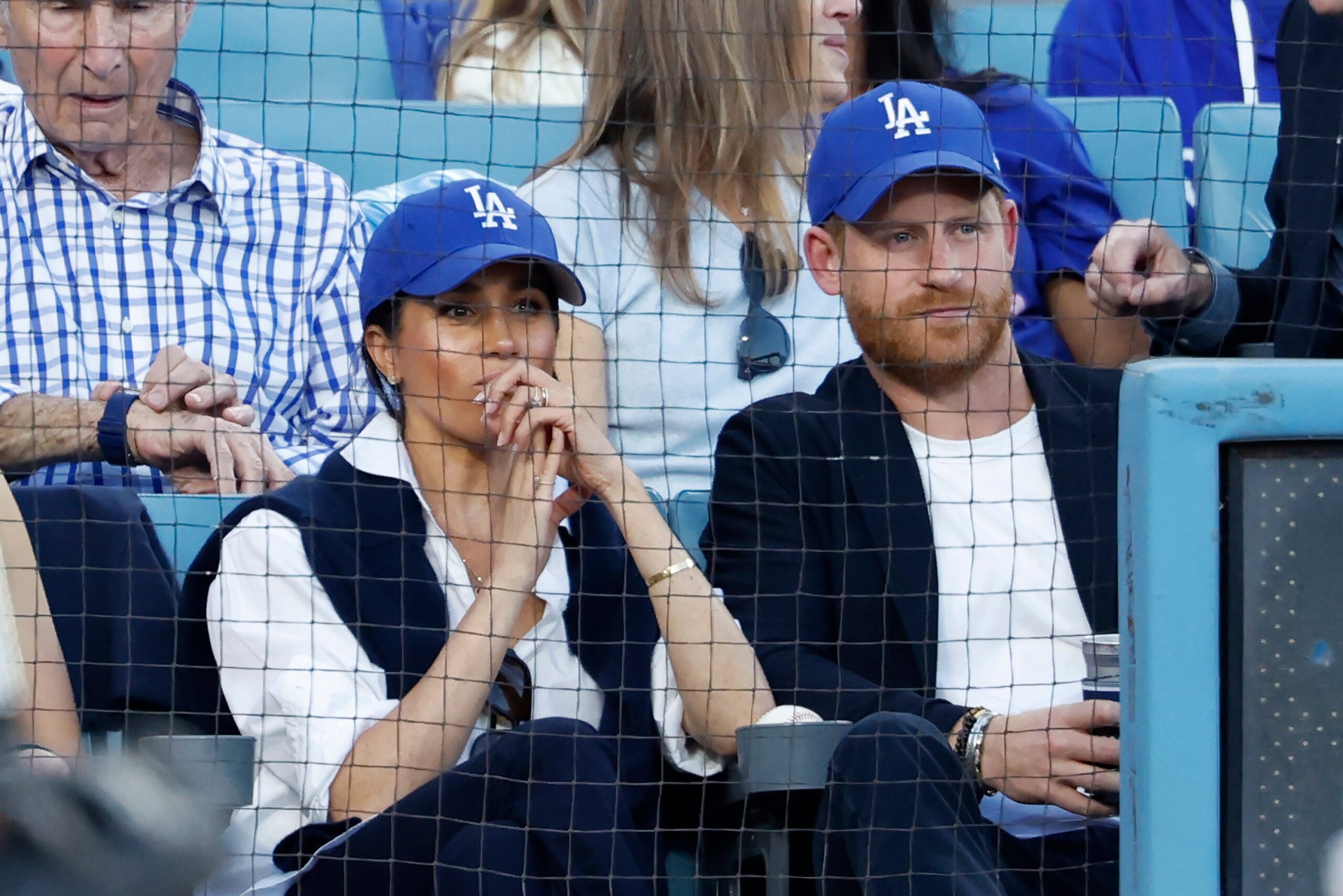 Prince Harry, Duke of Sussex and Meghan, Duchess of Sussex, look on from the stands during game four of the 2025 World Series between the Toronto Blue Jays and the Los Angeles Dodgers at Dodger Stadium