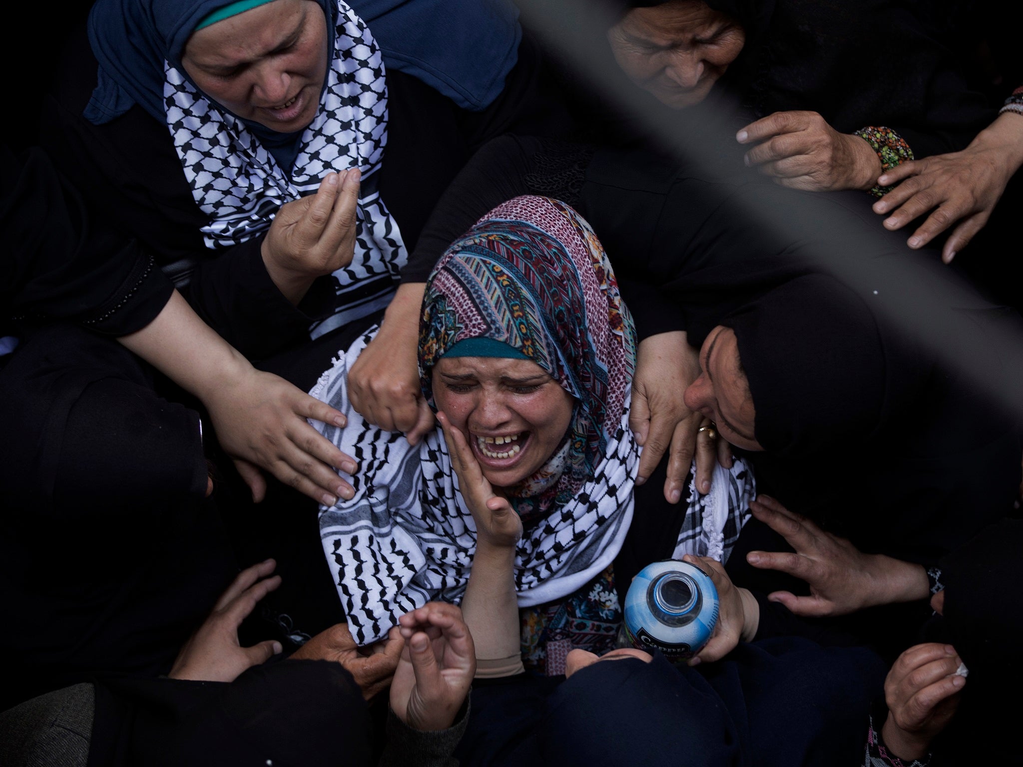Relatives of the volunteer paramedic mourn at the family house during her funeral in the town of Khan Younis, southern Gaza Strip