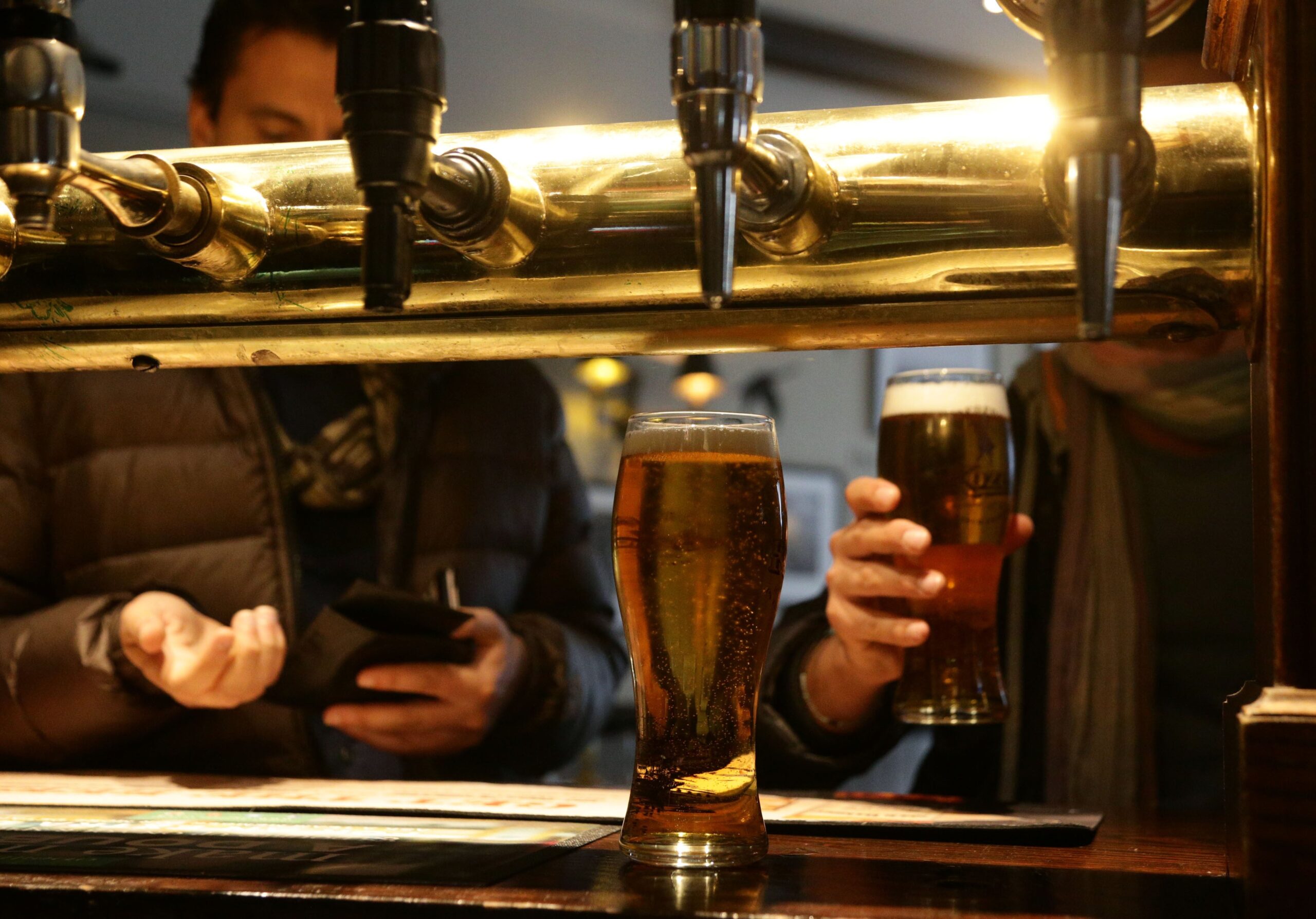 Customers collecting drinks at a bar