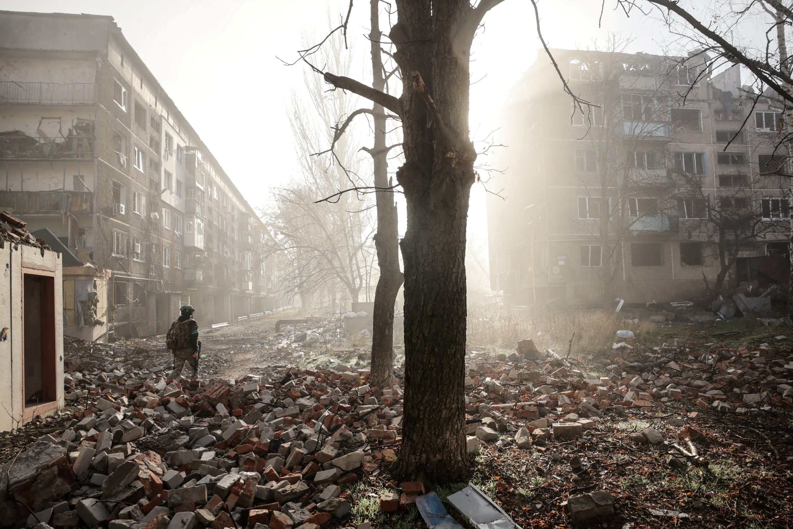 A Ukrainian serviceman walks near apartment buildings damaged by a Russian military strike in the frontline town of Kostiantynivka in Donetsk region.