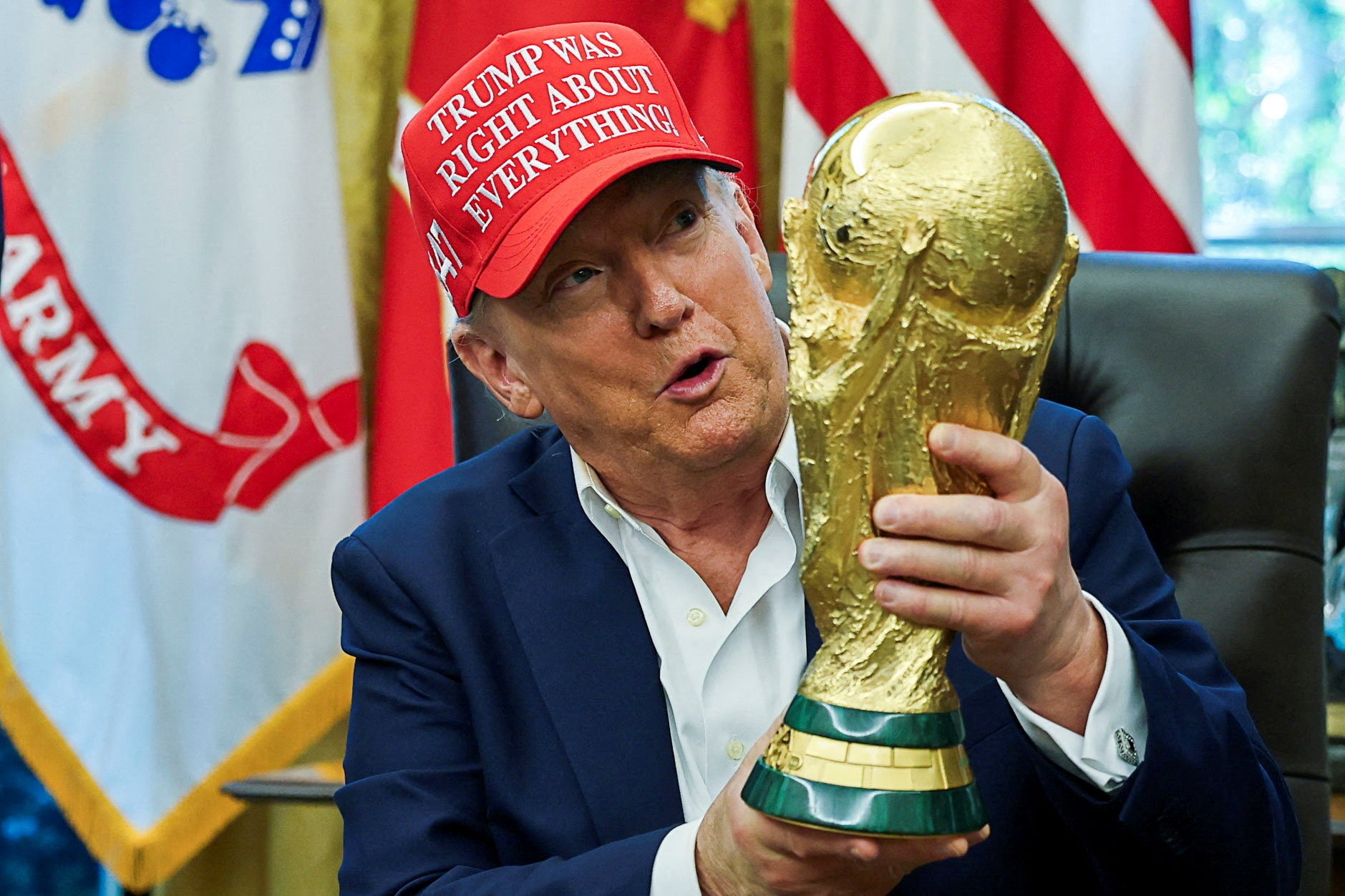 President Donald Trump holding a FIFA World Cup trophy. The Trump administration refused to comment on whether or not immigration agents would target foreign fans attending the 2026 World Cup in the U.S.