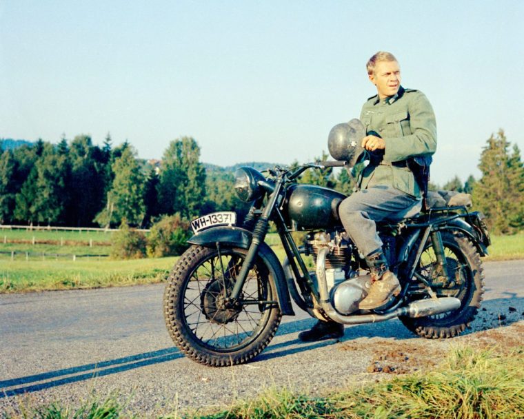American actor Steve McQueen (1930 - 1980) wearing a German military uniform, sitting astride a Triumph Bonneville motorcycle in a publicity still issued for the film, 'The Great Escape', 1963. The prisoner of war drama, directed by John Sturges, starred McQueen as Captain Virgil Hilts, aka 'The Cooler King', and was filmed in Bavaria, Germany. (Photo by Silver Screen Collection/Getty Images)