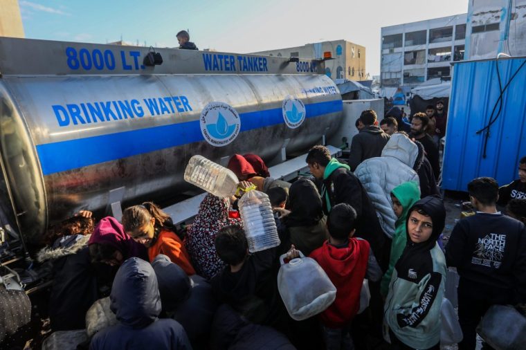 KHAN YUNIS, GAZA - DECEMBER 30: Palestinians gather to receive drink water distributed from water tankers to carry their living areas using jerry cans where infrastructure has been severely damaged and a water crisis has emerged due to Israeli attacks in Khan Yunis, Gaza on December 30, 2025. (Photo by Abed Rahim Khatib/Anadolu via Getty Images)