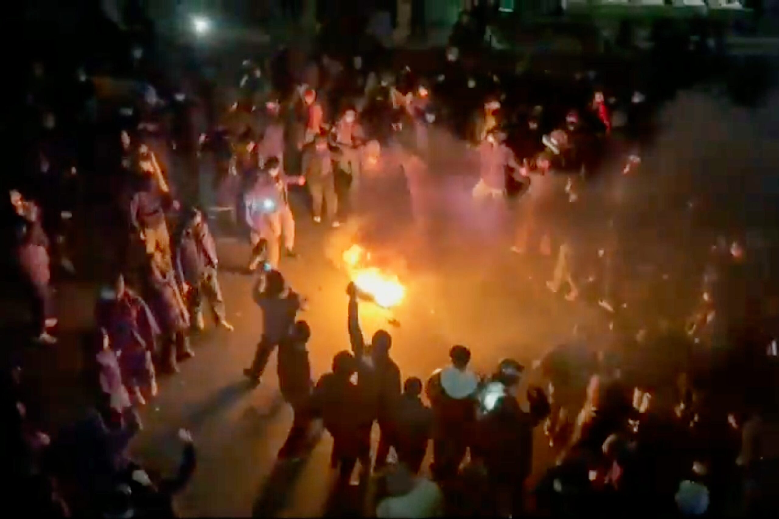 Protesters dancing around a bonfire on a street in Tehran