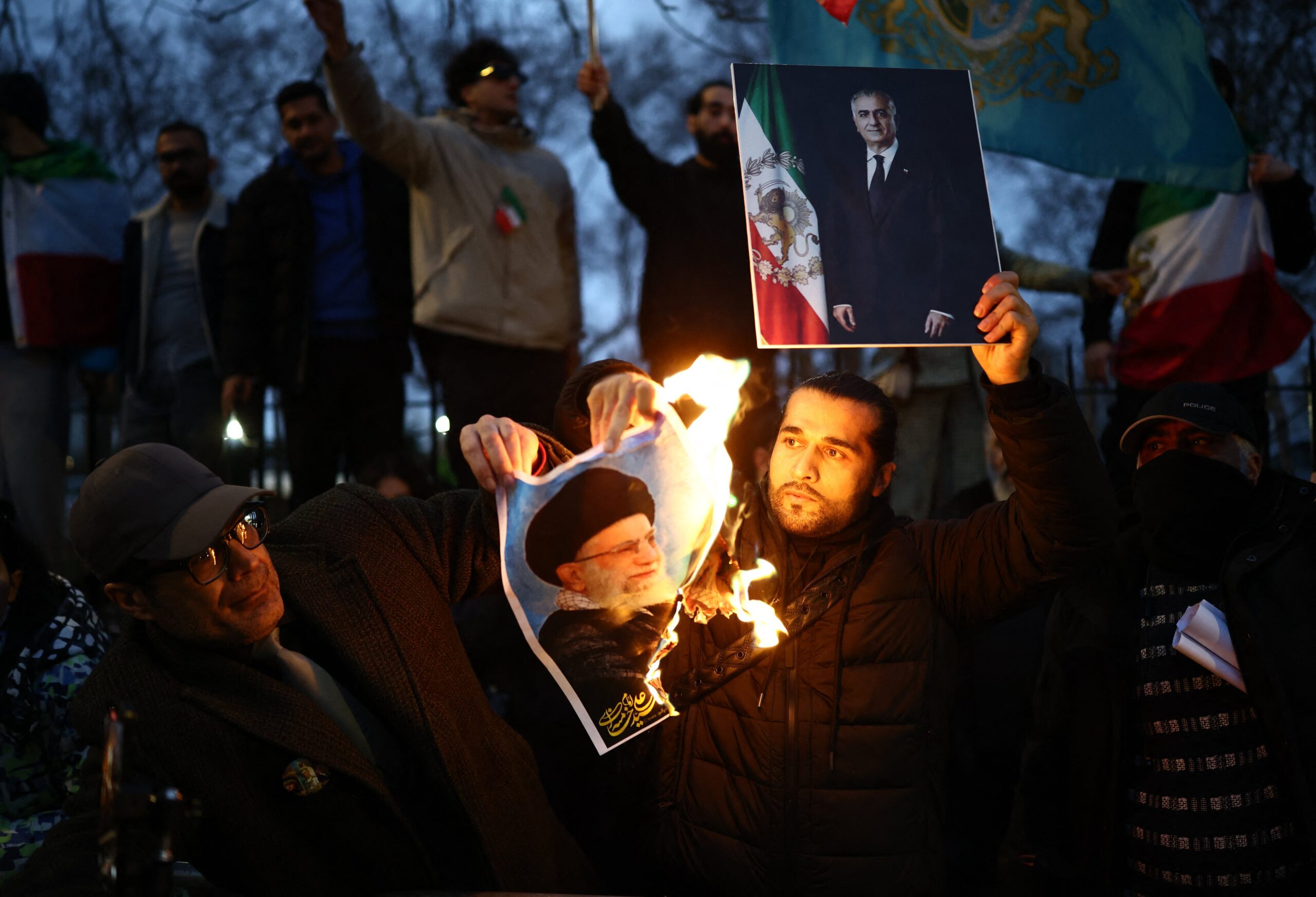 Anti-Iranian regime protesters burn an image of Ayatollah Ali Khamenei outside the embassy on Monday