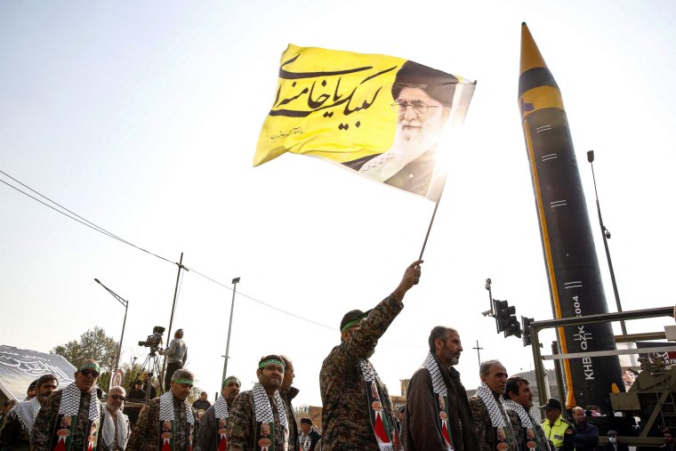 Members of Iranian paramilitary's Basij forces march next to the fourth generation Khorramshahr ballistic missile Khaibar displayed during an anti-Israeli rally to show their solidarity with Palestinians, in Tehran on November 24, 2023. (Photo by AFP) (Photo by STR/AFP via Getty Images)